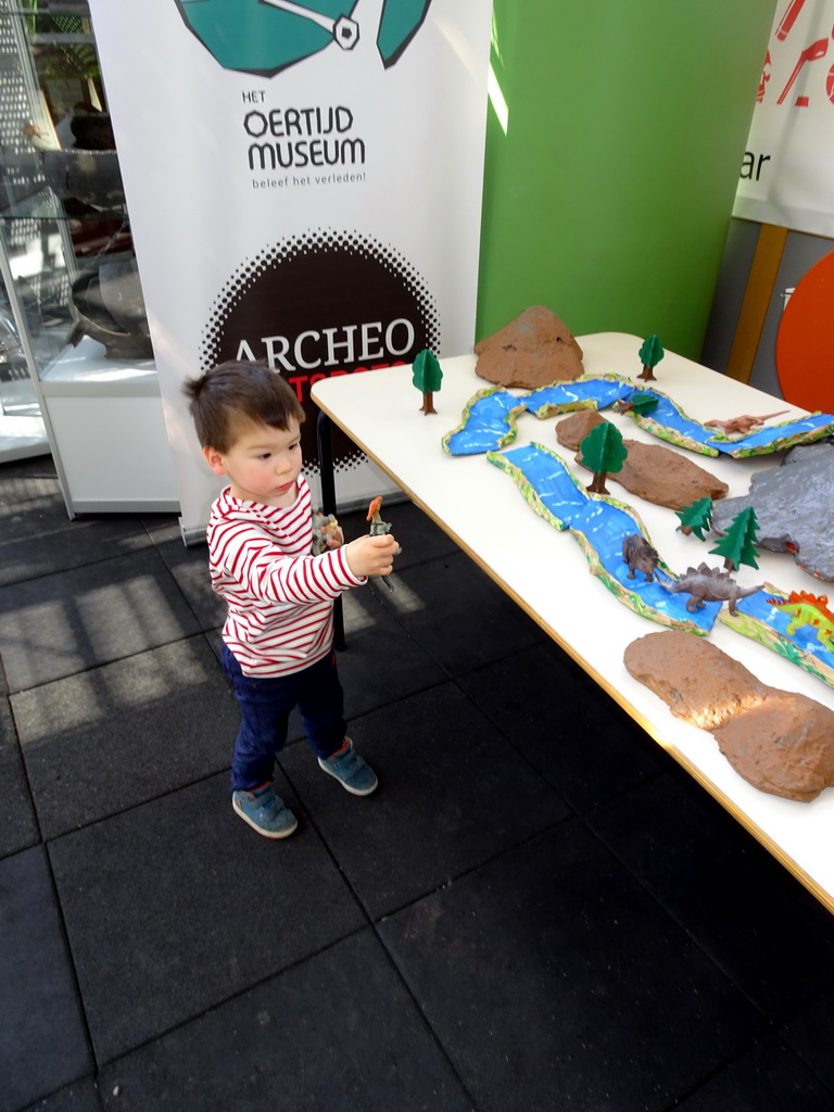 Max playing with dinosaur toys at the Middle Floor of the Dinohal building of the Oertijdmuseum