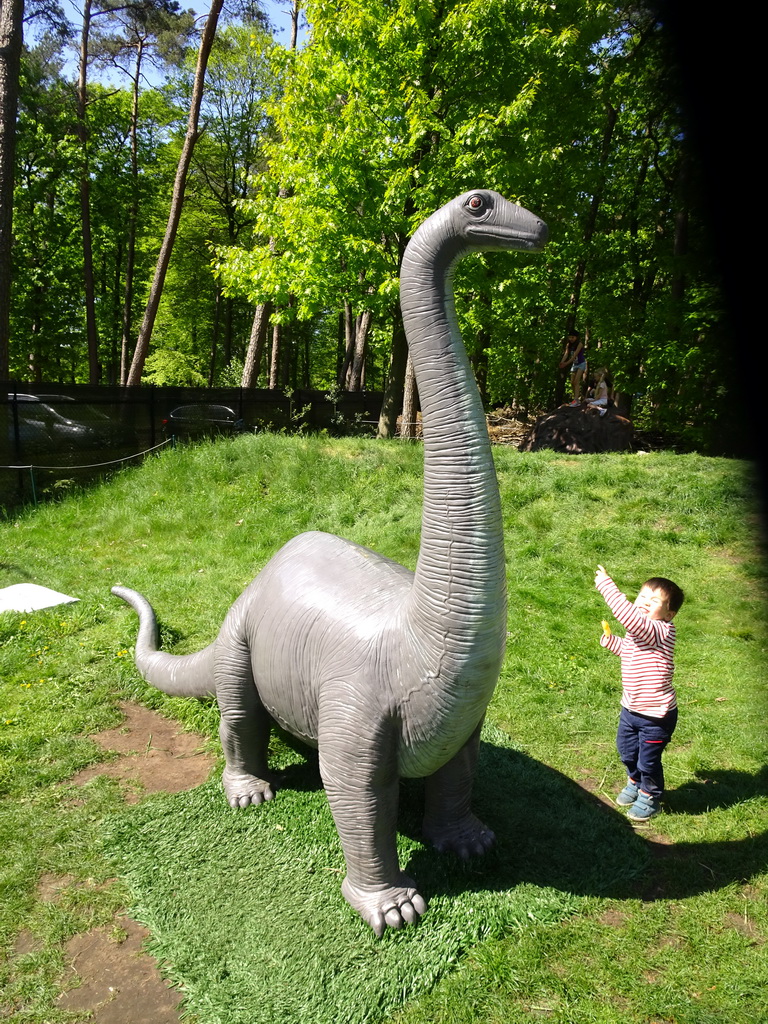 Max with a statue of a Diplodocus at the playground in the Oertijdwoud forest of the Oertijdmuseum