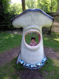 Max in a statue of the head of a Hammerhead Shark at the playground in the Oertijdwoud forest of the Oertijdmuseum