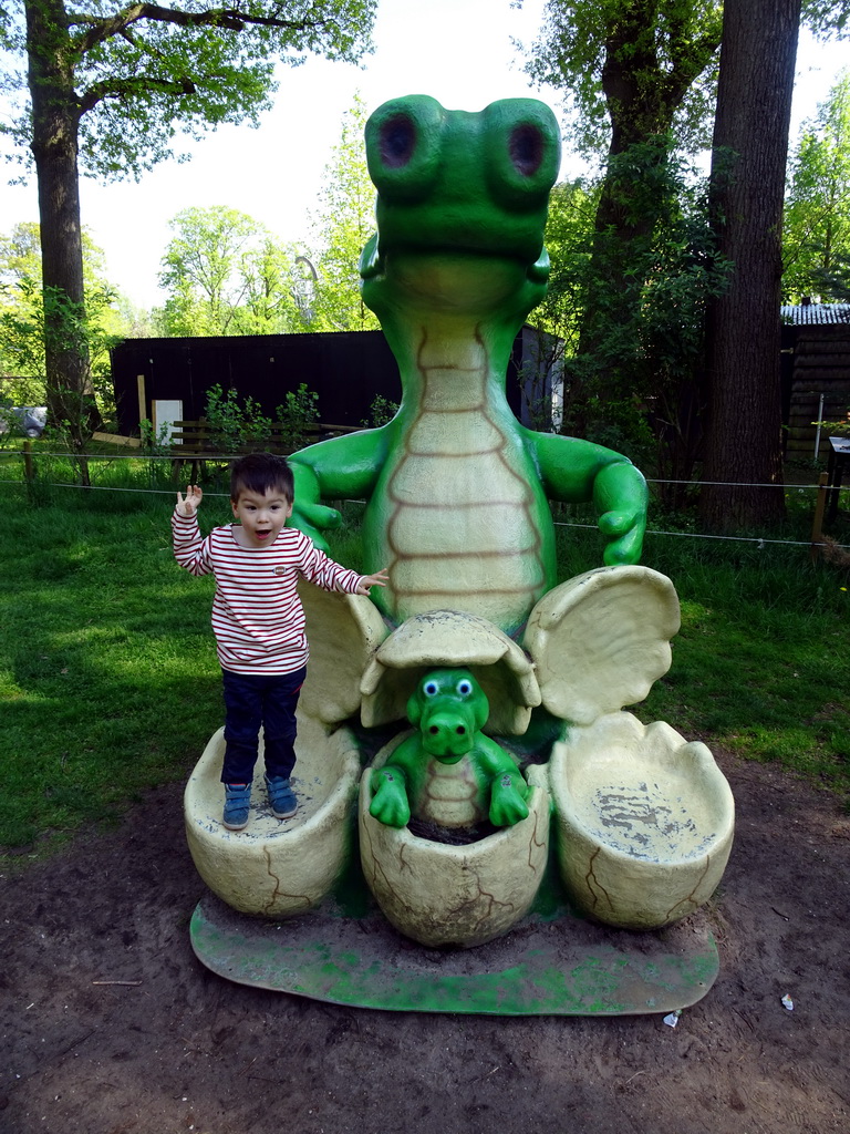 Max on a statue of a Crocodile with eggs at the playground in the Oertijdwoud forest of the Oertijdmuseum