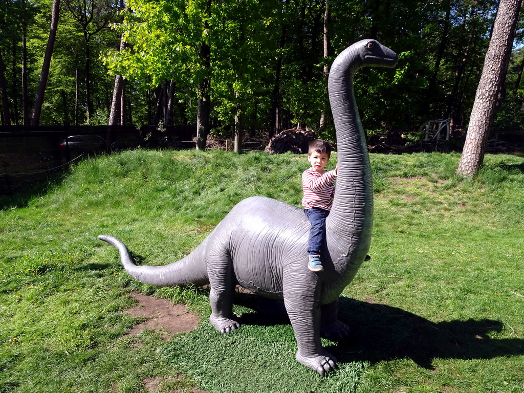 Max on a statue of a Diplodocus at the playground in the Oertijdwoud forest of the Oertijdmuseum
