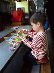 Max playing with a puzzle in the hallway from the Dinohal building to the Museum building of the Oertijdmuseum