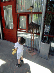 Max with a statue of an Ostrich in the hallway from the Dinohal building to the Museum building of the Oertijdmuseum
