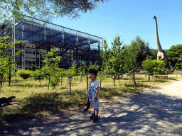 Max with a dinosaur toy in the Garden in front of the Dinohal building of the Oertijdmuseum