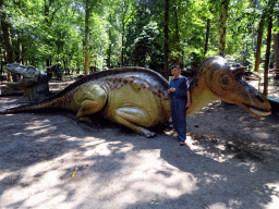 Miaomiao`s father with a dinosaur statue in the Oertijdwoud forest of the Oertijdmuseum