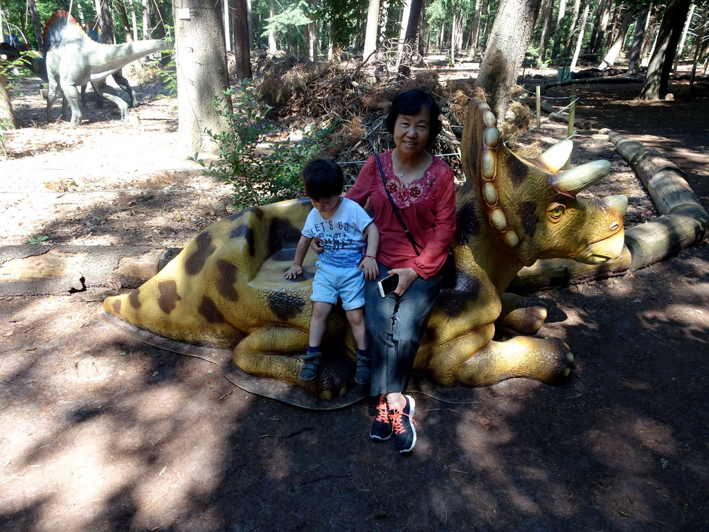 Max and his grandmother on a statue of a Triceratops in the Oertijdwoud forest of the Oertijdmuseum