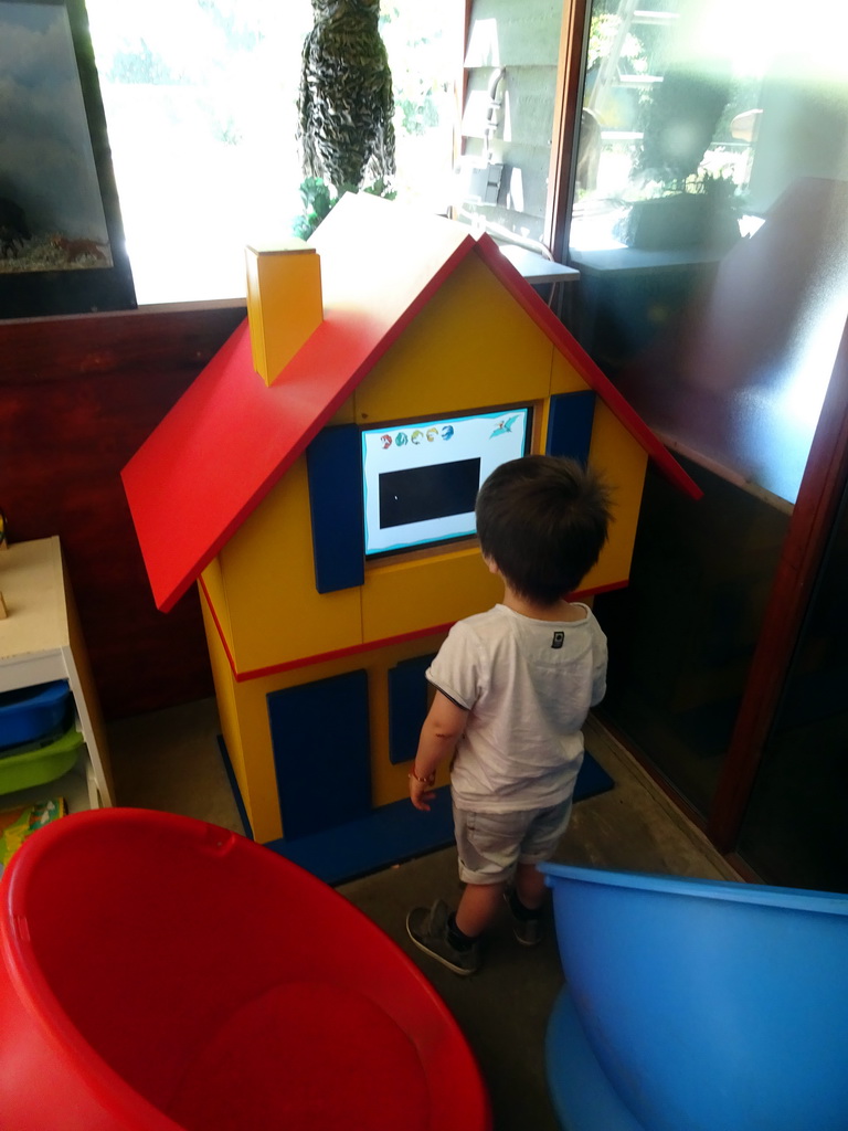 Max looking at a television screen in the hallway from the Dinohal building to the Museum building of the Oertijdmuseum