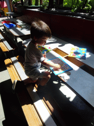 Max playing with a puzzle in the hallway from the Dinohal building to the Museum building of the Oertijdmuseum