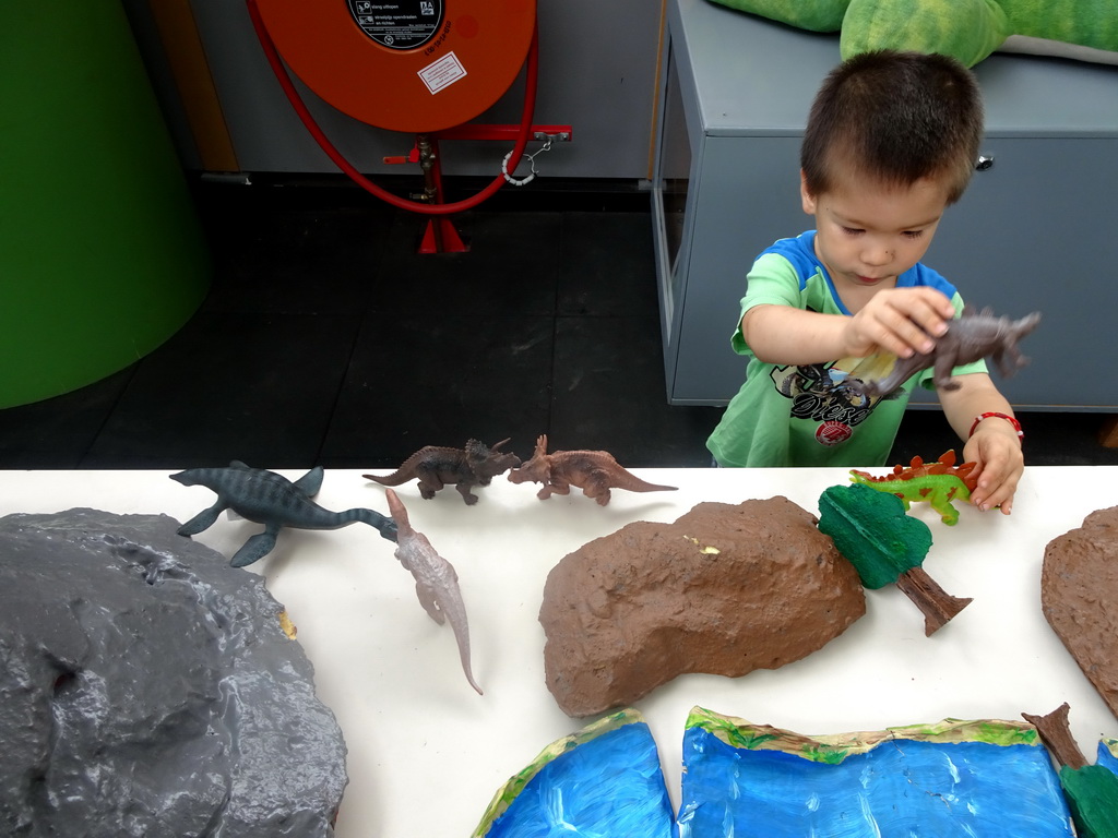 Max playing with dinosaur toys at the Middle Floor of the Dinohal building of the Oertijdmuseum