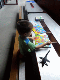 Max playing with a puzzle in the hallway from the Dinohal building to the Museum building of the Oertijdmuseum