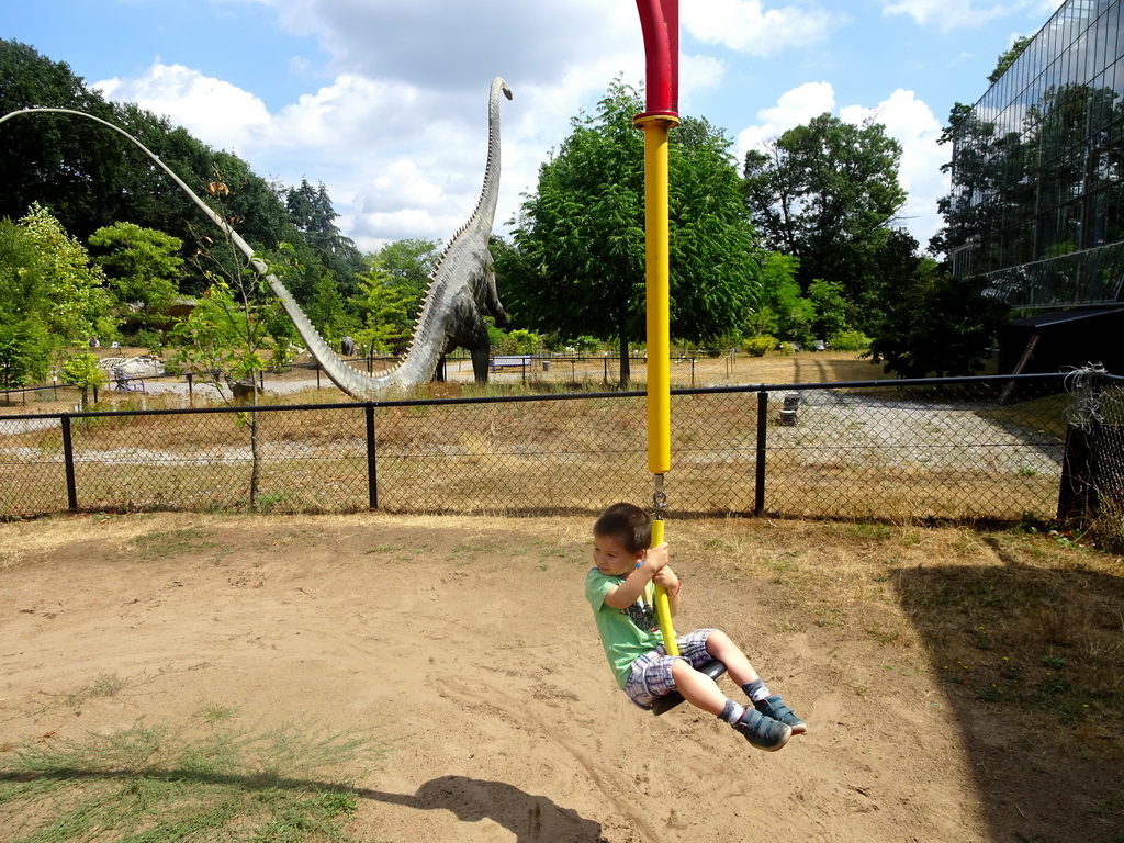 Max at the playground and a statue of a Diplodocus in the Garden of the Oertijdmuseum