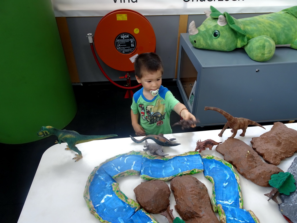 Max playing with dinosaur toys at the Middle Floor of the Dinohal building of the Oertijdmuseum