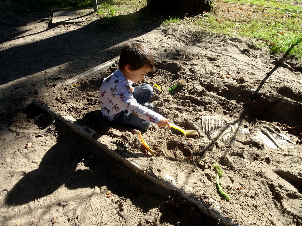 Max playing in the Velociraptor excavation sandbox in the Oertijdwoud forest of the Oertijdmuseum