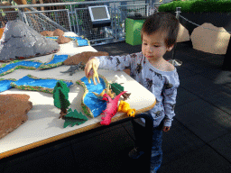 Max playing with dinosaur toys at the Middle Floor of the Dinohal building of the Oertijdmuseum