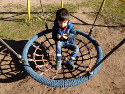 Max with an ice cream on a swing at the playground in the Garden of the Oertijdmuseum