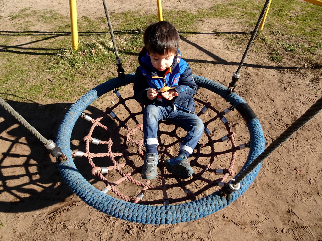 Max with an ice cream on a swing at the playground in the Garden of the Oertijdmuseum