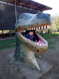 Max in a statue of the head of a Dinosaur at the playground in the Garden of the Oertijdmuseum