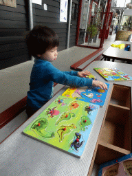 Max playing with a puzzle in the hallway from the Dinohal building to the Museum building of the Oertijdmuseum