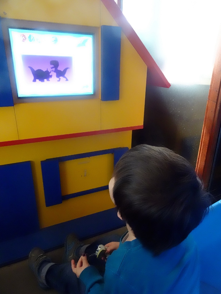 Max watching television in the hallway from the Dinohal building to the Museum building of the Oertijdmuseum