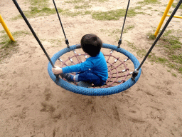 Max on a swing at the playground in the Garden of the Oertijdmuseum