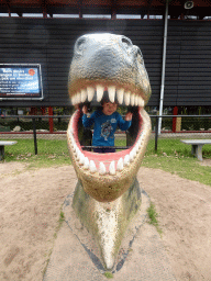 Max in a statue of the head of a Dinosaur at the playground in the Garden of the Oertijdmuseum