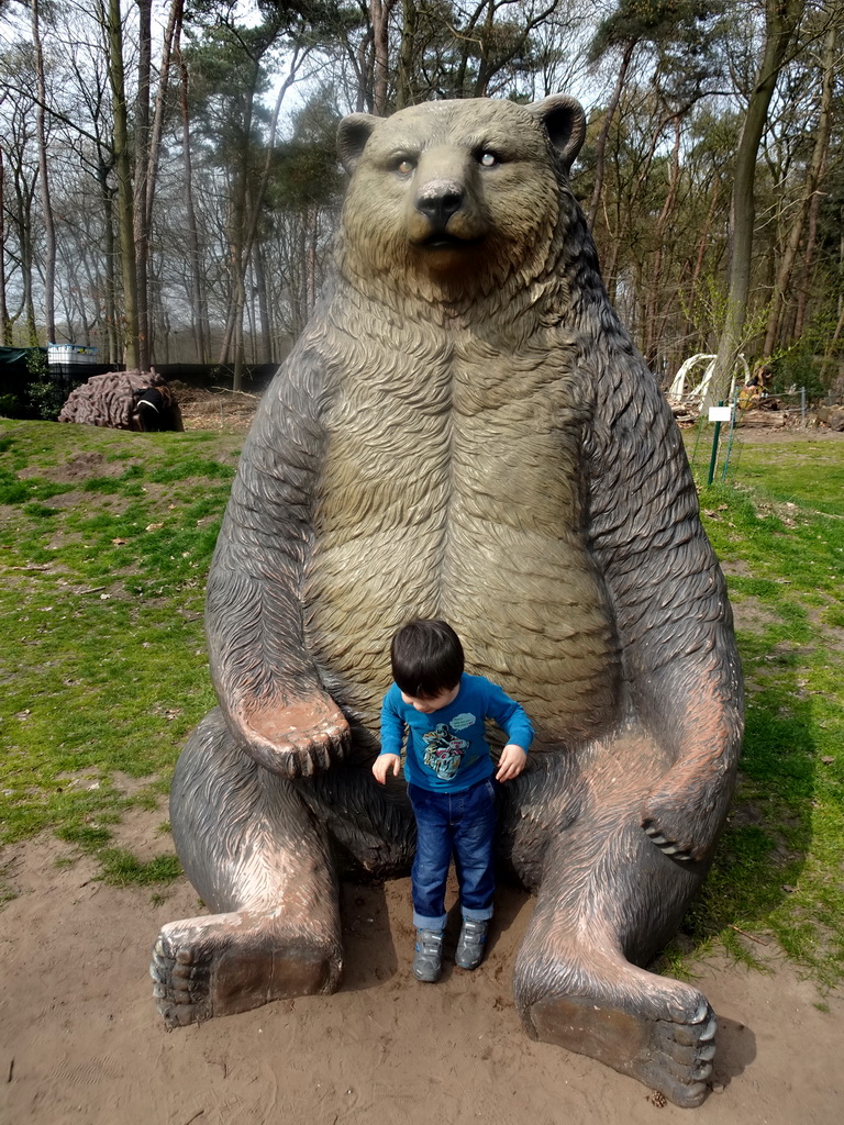 Max with a statue of a Bear at the playground in the Oertijdwoud forest of the Oertijdmuseum