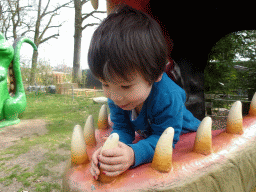 Max in a statue of the head of a Dinosaur at the playground in the Oertijdwoud forest of the Oertijdmuseum