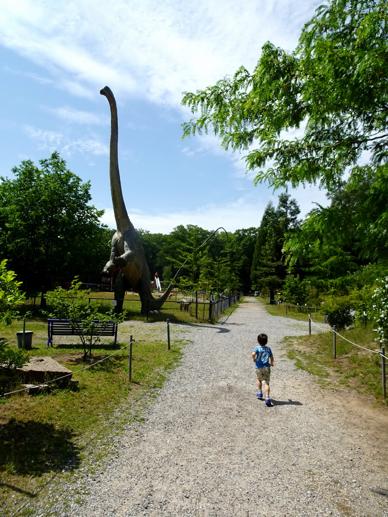 Max with a statue of a Diplodocus in the Garden of the Oertijdmuseum