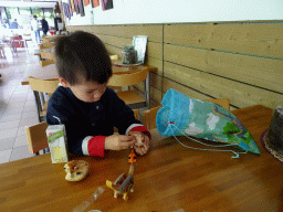 Max having lunch and playing with dinosaur toys in the restaurant at the Lower Floor of the Museum building of the Oertijdmuseum