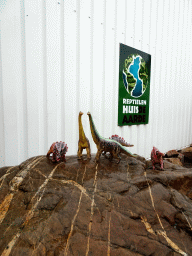 Entrance sign and dinosaur toys at the entrance to the Reptielenhuis De Aarde zoo at the Aardenhoek street