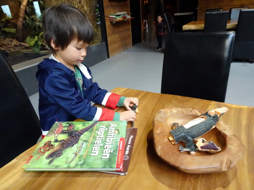Max with a crocodile toy and animal books at the lower floor of the Reptielenhuis De Aarde zoo