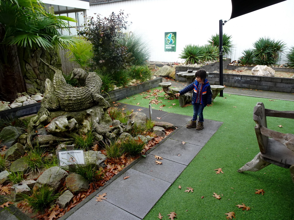 Max with a Crocodile statue in the garden of the Reptielenhuis De Aarde zoo