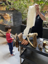 Max and a zookeeper with a snake skin at the lower floor of the Reptielenhuis De Aarde zoo