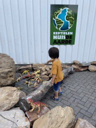 Max with entrance sign and dinosaur toys at the entrance to the Reptielenhuis De Aarde zoo at the Aardenhoek street