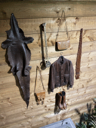 Items made of Crocodile and Snake skin on the wall of the Reptielenhuis De Aarde zoo, viewed from the left staircase