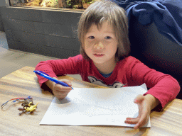 Max writing and drawing for the scavenger hunt at the lower floor of the Reptielenhuis De Aarde zoo