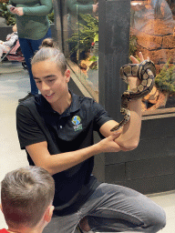 Zookeeper with a Ball Python at the lower floor of the Reptielenhuis De Aarde zoo