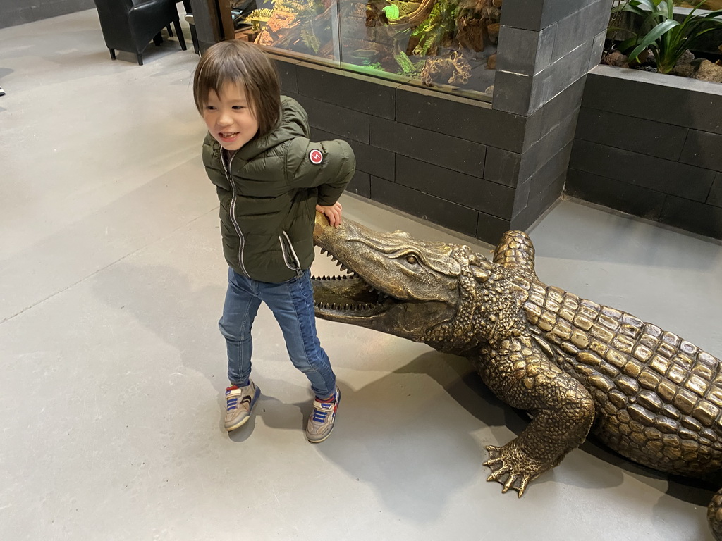 Max with a Crocodile statue at the lower floor of the Reptielenhuis De Aarde zoo