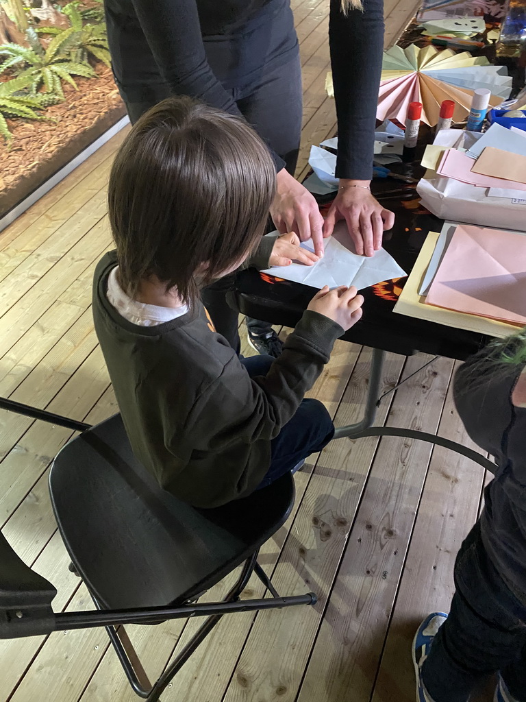 Max folding a paper ghost at the upper floor of the Reptielenhuis De Aarde zoo, during the Halloween 2020 event