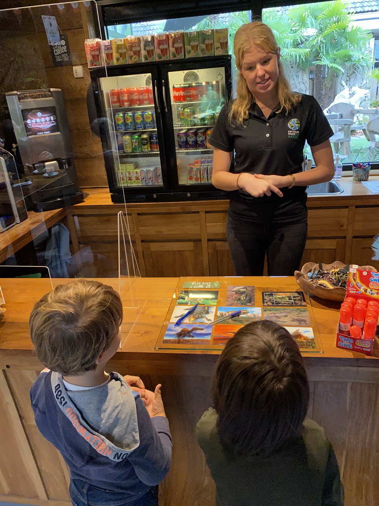 Max and his friend handing over their Halloween Quest paper to the zookeeper at the lower floor of the Reptielenhuis De Aarde zoo, during the Halloween 2020 event