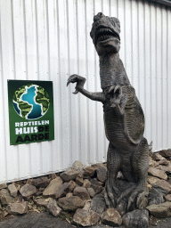 Entrance sign and statue of a Tyrannosaurus Rex at the entrance to the Reptielenhuis De Aarde zoo at the Aardenhoek street