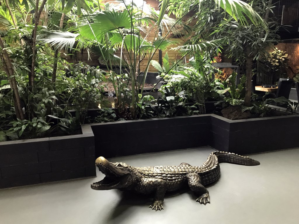 Crocodile statue and plants at the lower floor of the Reptielenhuis De Aarde zoo