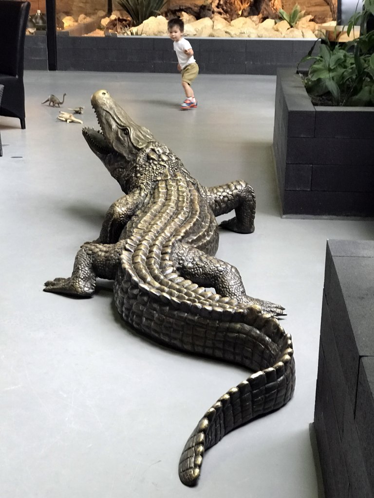 Max with a crocodile statue at the lower floor of the Reptielenhuis De Aarde zoo