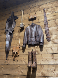 Items made from reptile skin on the wall of the Reptielenhuis De Aarde zoo, viewed from the lower floor