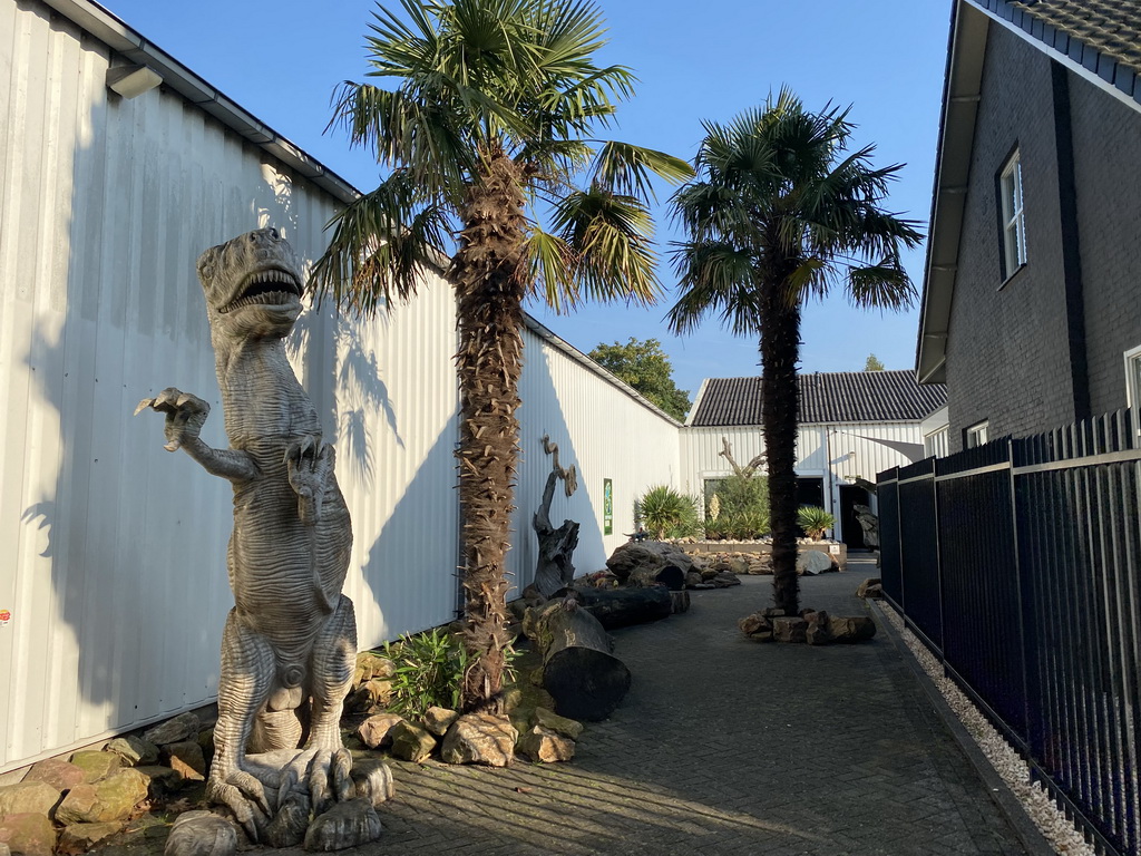 Statue of a Tyrannosaurus Rex and the garden of the Reptielenhuis De Aarde zoo at the Aardenhoek street