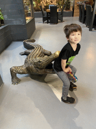 Max with a Crocodile statue at the lower floor of the Reptielenhuis De Aarde zoo