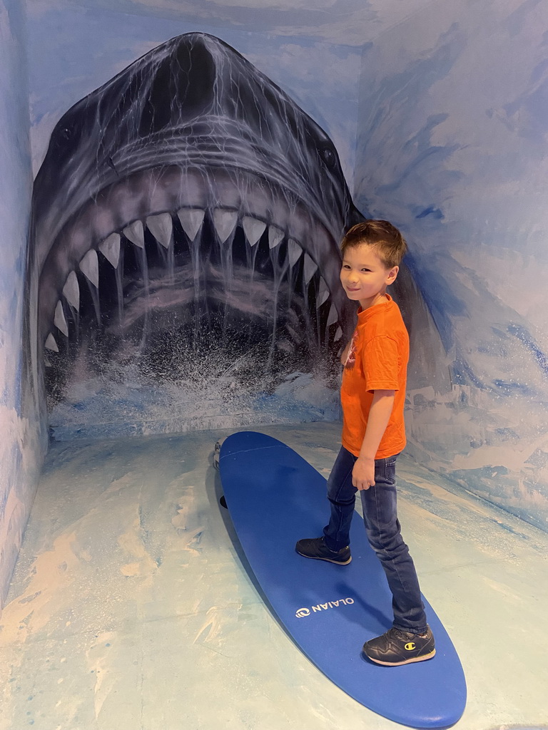 Max surfing in front of a shark at the SuperNova Experience museum