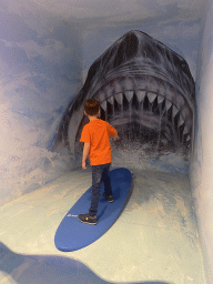 Max surfing in front of a shark at the SuperNova Experience museum