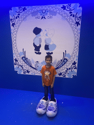Max with wooden shoes in front of a Delfts Blauw painted tile at the SuperNova Experience museum