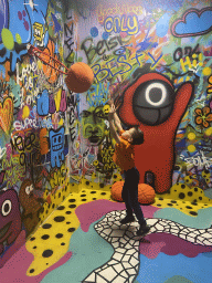 Max throwing a basketball at the graffiti room at the SuperNova Experience museum